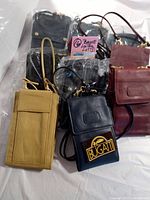 Top view showing all nine Bugatti handbags in various colors including black, gold brown, burgundy red. Bags are rectangular with long shoulder straps, new vintage condition.