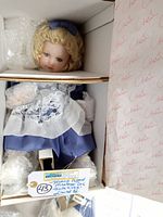 Marie Osmond porcelain doll in original box, dressed in blue with lace, labeled and numbered.