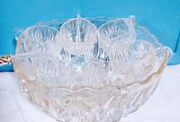 Top angle showing punch bowl with six cups hooked around the edge and ladle inside
