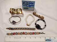 Full view of all seven bracelets arranged on a white surface with a sign indicating "50 Vintage Bracelets Lot 07"