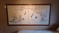 Full view of the 4-panel oriental art screen mounted on a wall, showing cranes and floral artwork on each panel with dark brown framing.