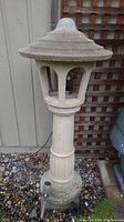Front view of assembled concrete pagoda lantern showing roof, housing, pedestal.