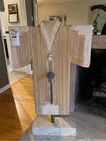 Front view of kimono statue showing carved linear details and pendant