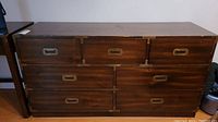 Front view of the Kroehler wood dresser showing seven drawers with brass inset handles and visible surface scratches.