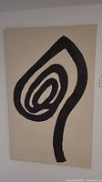 Full view of the abstract painting showing large black spiral shape on cream canvas.