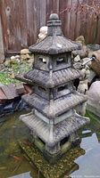 Front view showing entire four-level lantern in pond
