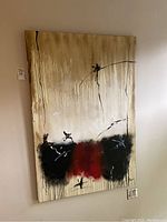 Full view of the signed abstract painting hanging on the wall showing the overall composition, colors, and signature.