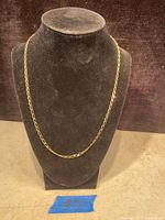 Full view of 10K gold chain displayed on black velvet bust to show link style and length.