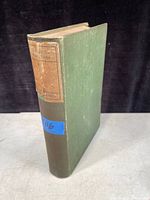 Antique book with green cover and worn spine label showing title and author details.