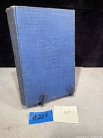 Front cover of the blue hardcover book showing age wear and frayed edges.