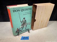 Front cover of the hardcover book showing Don Quixote illustration and slipcase beside it