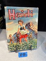 Photo of front cover of the Heidi book showing colorful illustrated girl with goats and mountain background.