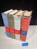 Four hardcover volumes of Winston Churchill's 'A History of the English Speaking Peoples' standing upright showing dust jackets with wear and edge damage