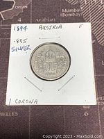 Obverse side of the 1894 Austria 1 Corona silver coin showing the crowned emblem and floral designs.