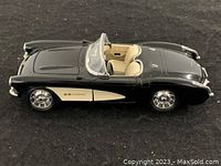 Side angled view of the 1967 black Corvette die cast model showing profile, cream interior, wheels, and exterior details.