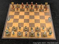 Full view of chess set with all pieces arranged on board showing two-tone squares and themed figures