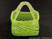 Side view of green glass basket showing handle and striped design