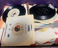 Loose and sleeved 7" 45 RPM records stacked in a bin