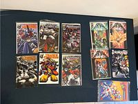 Overview of 11 comics including Transformers, Transformers Armada, Battle of the Planets and others laid flat on a surface.