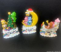 Three Care Bears Christmas figures displayed on a black background showing all three items together