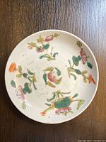 Top view of the round Chinese porcelain plate showing hand-painted floral patterns in multiple colors, with visible cracking.