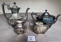 Four-piece antique silver-plated Birks Ryrie tea and coffee set including coffee pot, teapot, sugar bowl, and creamer with tarnished surfaces.