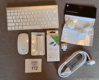 Apple wireless keyboard, Magic Mouse, original remote control in packaging, Nextech Lightning charge/sync cable in packaging, Mini-DVI to VGA adapter in packaging, power adapter, power plug