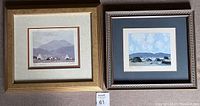 Photo of two framed limited edition prints by Paul Henry, one with a gold textured frame and the other with a brown frame. Both show rural landscapes and numbered signatures.