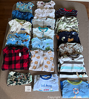 All sleepers and pyjamas arranged flat on a table showing colors, patterns, and style variety