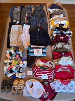 Overview of all items including pants, sweaters, socks, bibs, and footwear arranged on a table