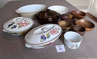 Top view of set of baking dishes and wooden bowls arranged on carpet with lot number card