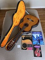 Guitar in open case with three instructional books laid out