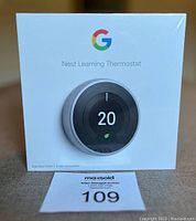 Front image of sealed Google Nest Learning Thermostat box showing product front with digital temperature display and stainless steel ring.