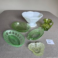 Photo showing full set of 5 uranium glass dishes in various shapes and one white milk glass bowl.