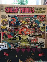 Front of the album cover showing the colorful comic-style artwork and band/album details.