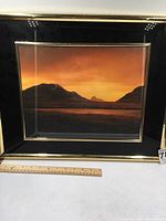 Framed mountain sunset photo, showing the photo and the frame with dimensions approximately 14 by 20 inches.