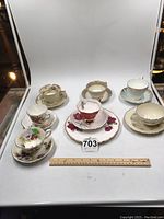 Front view of collection of six teacups with matching saucers, various floral patterns and trims.