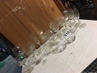 Multiple pieces of clear stemware displayed on a white cloth against a wood background, showing different sizes and styles.