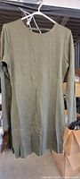 Front view of single olive green long sleeved dress with round neckline on hanger.