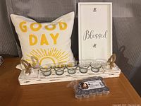 Lot contents with candle holder, throw pillow, frame, and extra tea lights