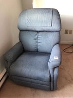 Front view of blue recliner chair showing padded cushions and fabric upholstery with slight wear.