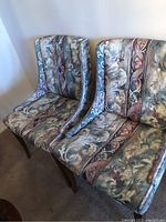 Pair of occasional chairs side by side showing upholstery pattern and wooden legs
