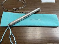 Pendant pen and chain atop Tiffany blue pouch