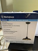 Westinghouse pendant light box showing 1-light oil rubbed bronze finish, Iron Hill model, adjustable cable length