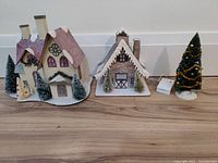 Photo of entire Christmas village set showing buildings, trees, and decorated Christmas tree with base.