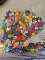 Two bags of assorted colorful plastic Gogo's Crazy Bones collectible figurines shown from above on a surface.