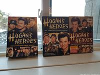 Photo showing three DVD box sets of Hogan's Heroes placed on a window sill. First season, second season (40th Anniversary Edition), and third season are displayed.