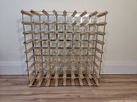 Front view of the full wine bottle rack showing its wood and acrylic grid design.