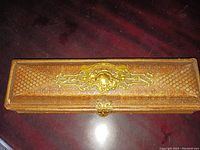 Top view of the rectangular leather glove box showing the worn embossed pattern and golden clasp.