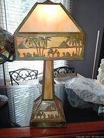 Full view of slag glass table lamp with pyramid scene illuminated